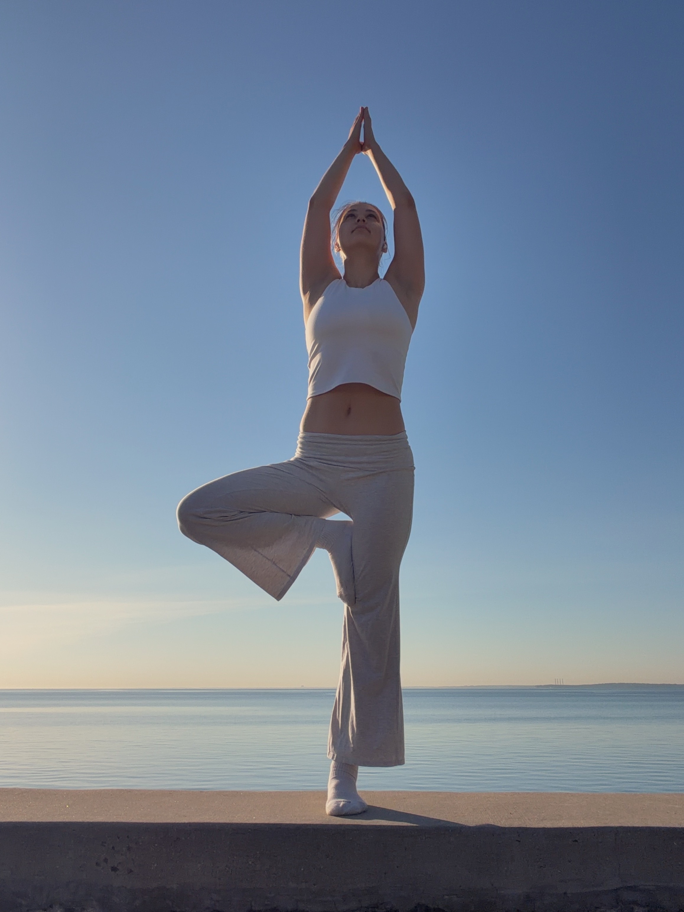 Nataliia practicing tree pose by the water